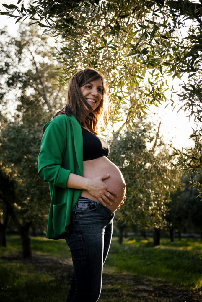 Mujer embarazada entre olivos